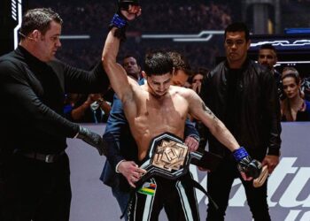 Eoghan Chelmiah has his hand raised by referee Marc Goddard as MMA great Lyoto Machida looks on. Photo: Karate Combat/Instagram